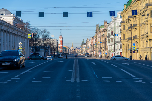 Russia, Saint Petersburg - February 27, 2022: Nevsky Prospekt with few cars in the early winter morning with clear blue sky. Saint Petersburg cityscape. Soft focus. Morning traffic theme.