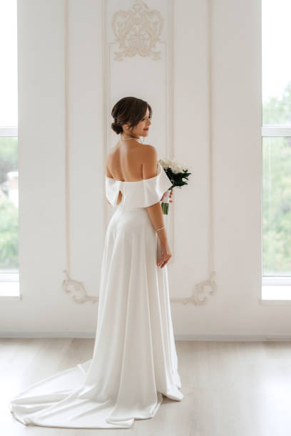 istock brunette bride in a tight wedding dress in a bright studio 1474398760