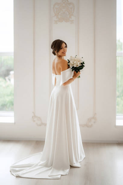 istock brunette bride in a tight wedding dress in a bright studio 1474400047