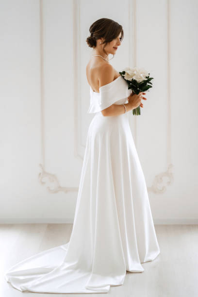 istock brunette bride in a tight wedding dress in a bright studio 1474400088