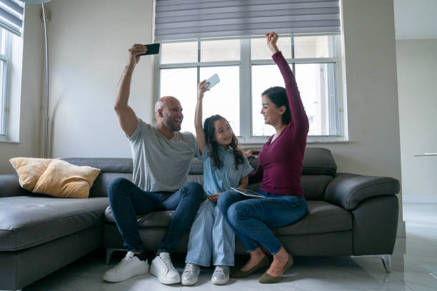 istock Family having good time and using portable devices at home sofa 1474400207