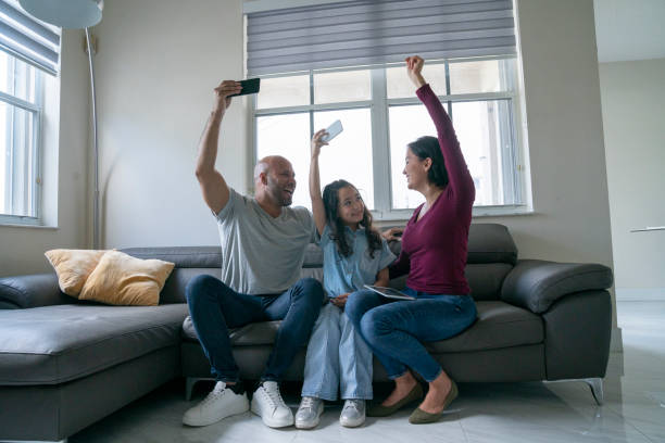 istock Family having good time and using portable devices at home sofa 1474400211