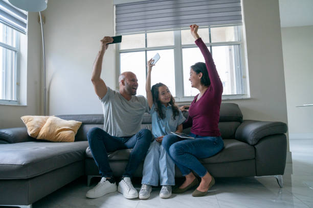 istock Family having good time and using portable devices at home sofa 1474400216