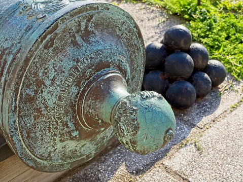 Ornate cannon etchings and cannonballs in background at Castillo de San Marcos. Saint Augustine Florida famous Spanish fort.