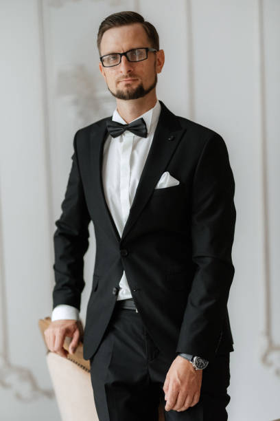 istock groom in a black suit with a bow 1474401295