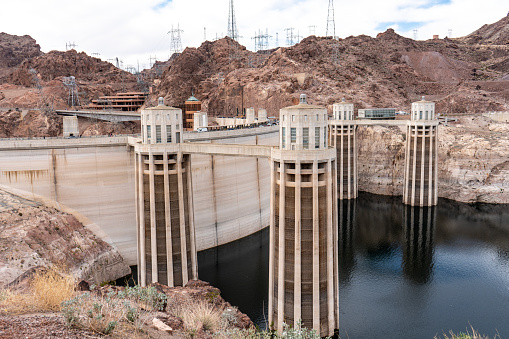 In 2020's the Hoover Dam Intake Towers loom far above the upper-side of the dam due to devastating drought and massive depletion of the water by people, industry and agriculture seeing a 175 foot drop from its high-mark.