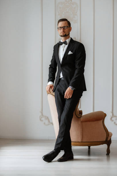 istock groom in a black suit with a bow 1474402620