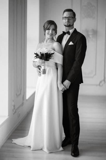 istock groom in a black suit tie and the bride in a bright studio 1474403590