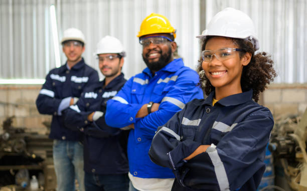 istock Group of confident technicians workers team standing at industrial factory 1474403709