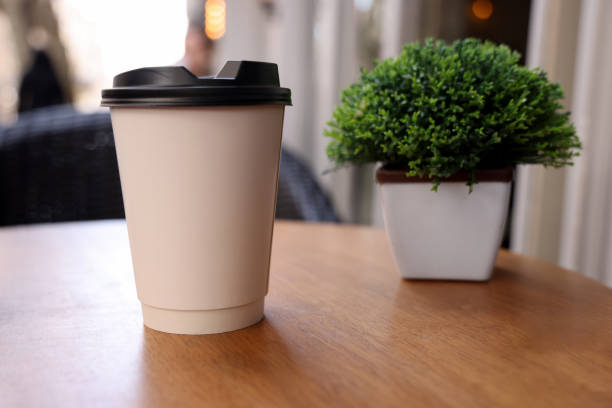 istock Coffee paper cup on wood table in coffee shop 1474405885