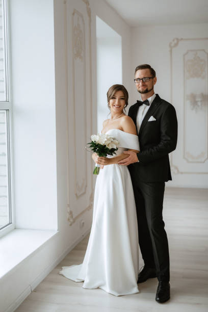 istock groom in a black suit tie and the bride in a bright studio 1474406631