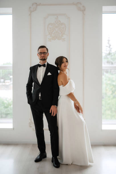 istock groom in a black suit tie and the bride in a bright studio 1474407275