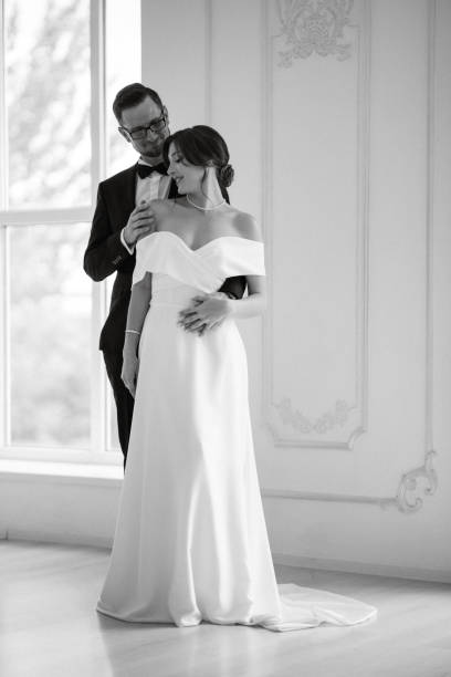 istock groom in a black suit tie and the bride in a bright studio 1474407340