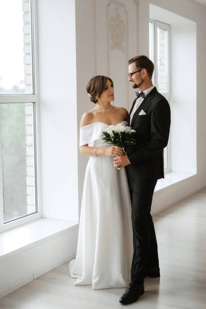 istock groom in a black suit tie and the bride in a bright studio 1474408490