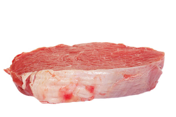 Pieces of meat from above on wooden cutting board of butcher shop with spices and hatchet