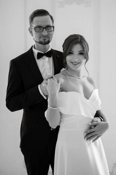 istock groom in a black suit tie and the bride in a bright studio 1474409696