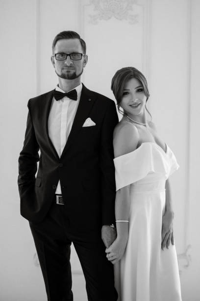 istock groom in a black suit tie and the bride in a bright studio 1474411801