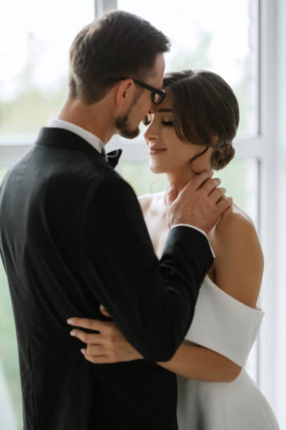 istock groom in a black suit tie and the bride in a bright studio 1474414859