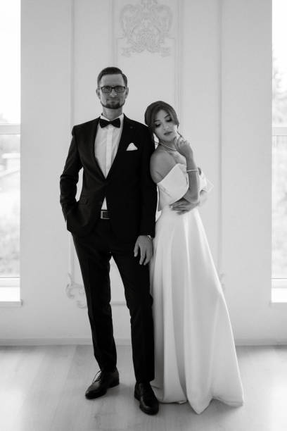 istock groom in a black suit tie and the bride in a bright studio 1474415237