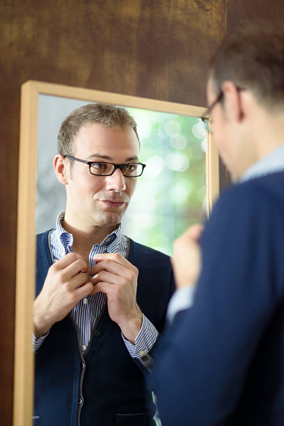 istock Young man dressing up and looking at mirror 147441605