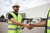 Foreperson greeting a coworker with a handshake at a distribution warehouse