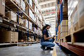 Woman working at a distribution warehouse making an inventory and scanning items