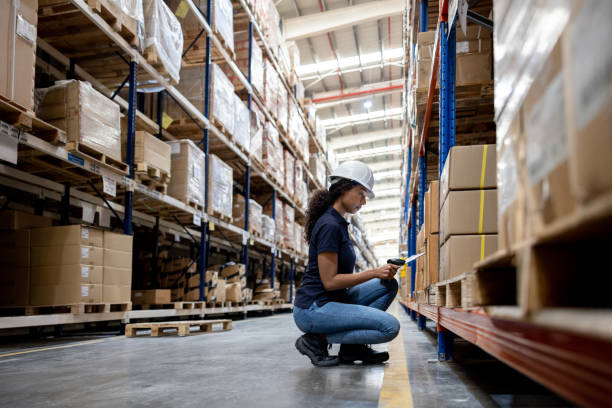 Woman working at a distribution warehouse making an inventory and scanning items stock photo