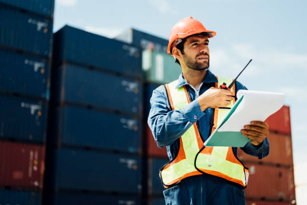 istock Industrial worker with walkie-talkie checking in cargo freight ship 1474426728