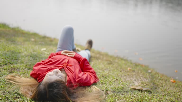 Beautiful Asian female tourist sleeping next to the river