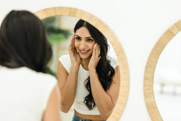 istock Young Woman Putting Face Cream 1474427714