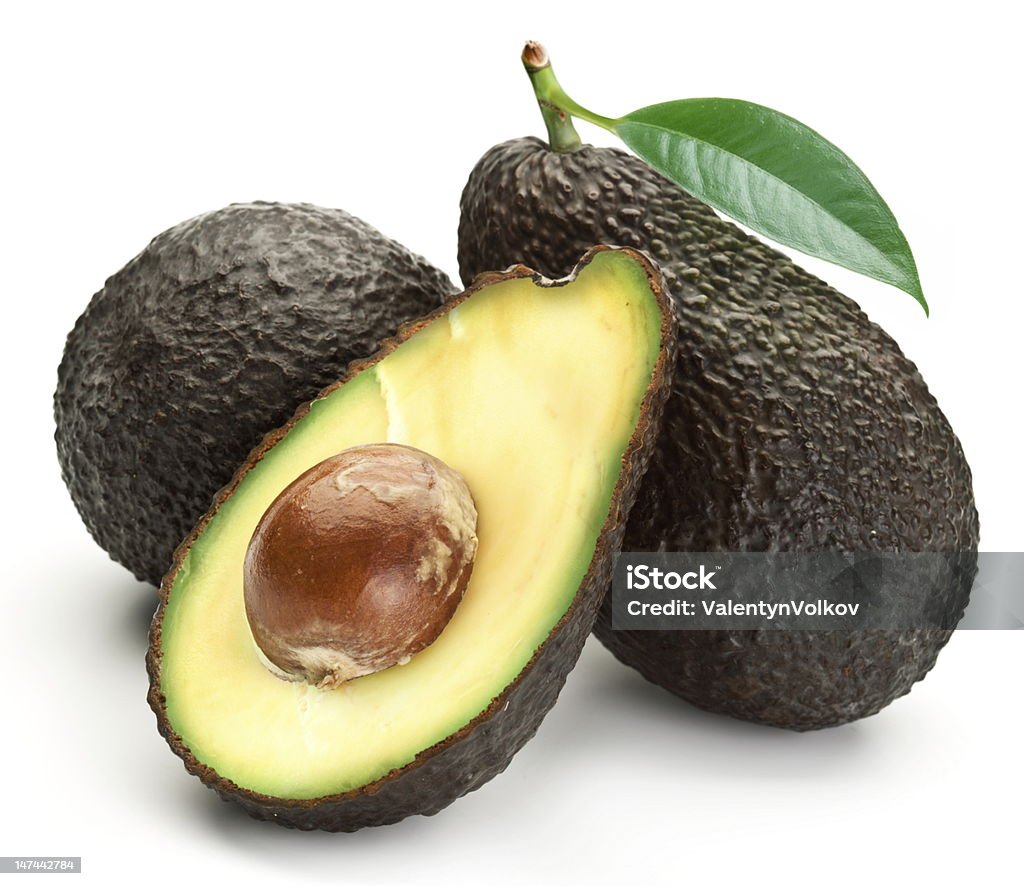 Two whole avocados with leaves and one half Avocado with leaves on a white background  Hass Avocado Stock Photo