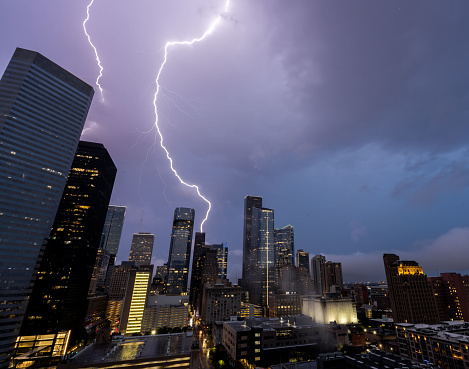Bolts of lightning and storm clouds over the Houston, TX downtown skyline during an early morning thunderstorm.