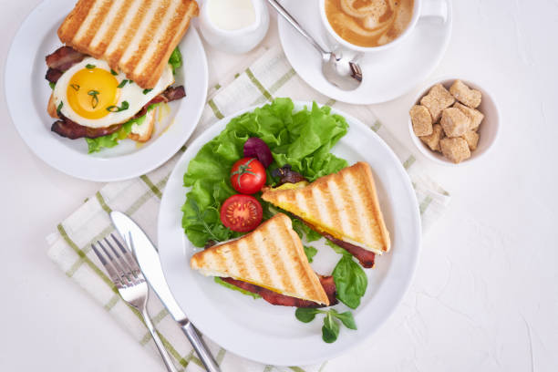 istock Tasty breakfast - sandwiches with fried eggs and bacon and fresh hot coffee 1474437155