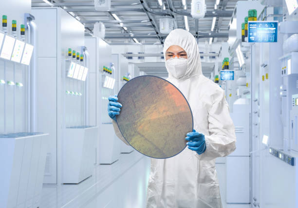 Worker or engineer wears medical protective suit or coverall suit with silicon wafer stock photo