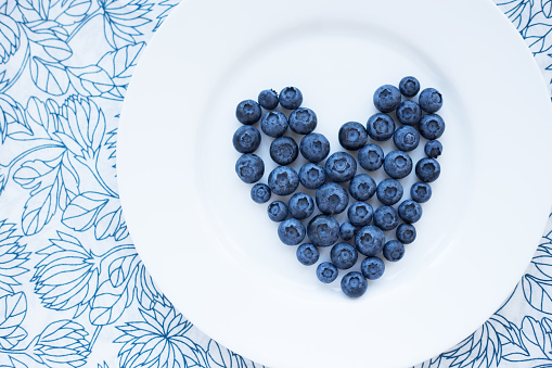 blueberries in a heart shape on a white plate. valentine card