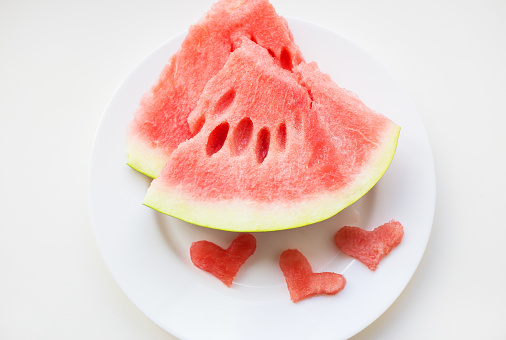 on the plate are two pieces of watermelon and a small heart-shaped