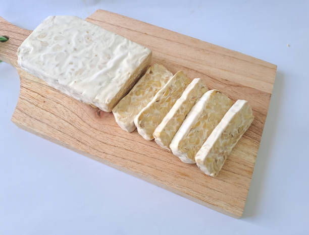 istock Beautiful sliced raw tempe or tempeh on a wooden cutting board isoloted white background 1474442007
