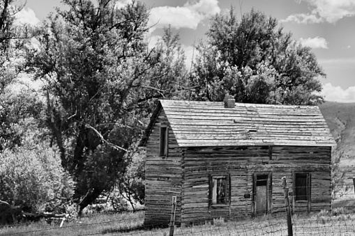 Monochromatic image old abandoned pioneer homestead, piece of the past, weathered  wood cabin. Randolph, Utah, USA.