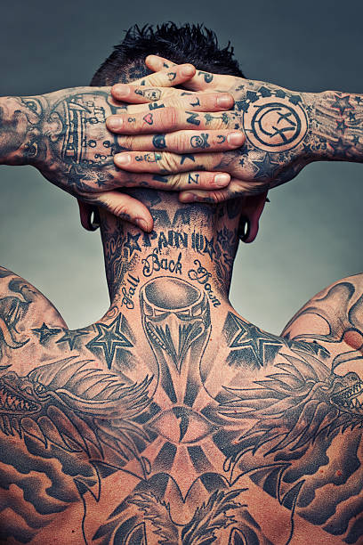 Tattoo artist back Rear view of a young man with a lot of tattoos and piercings. Hands on his head tattoo stock pictures, royalty-free photos & images