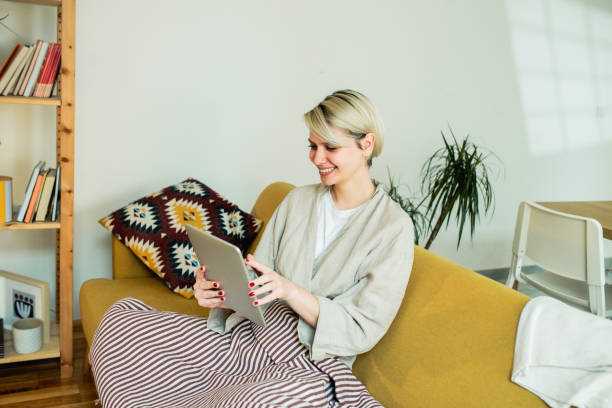 istock Young woman using digital tablet at home 1474449098