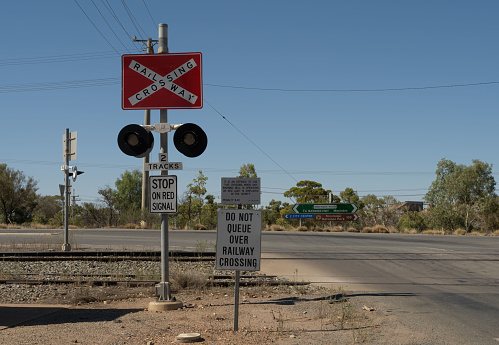 Railway crossing in Broken Hill at the junction of Menindee Road Great Barrier Highway. Signs show directions to Menindee, Kinchega National Park, and City Centre (Broken Hill).