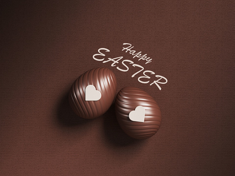 Easter concept chocolate Easter eggs heart shape and happy Easter text on brown color background
