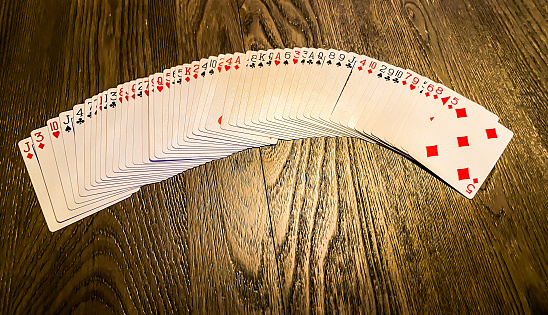 A deck of cards sits splayed out on a table.