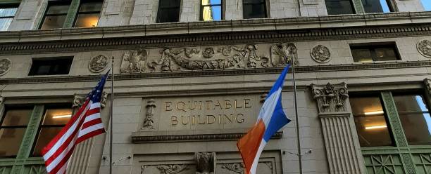 znak equitable building otoczony flagami w nowym jorku - equitable building zdjęcia i obrazy z banku zdjęć