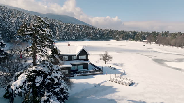 Popular locations of Turkey, aerial view of frozen lake in Bolu in winter and Gölcük nature park, lakeside house, lake house in snowy season, frozen lakeside country house, deserted house in snowy forest, most beautiful house