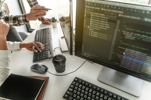 Programmer Writing Program Code With Two Monitors And Working On A New ...