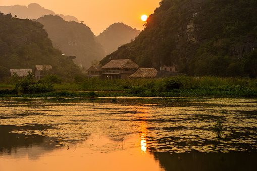 Water lake and big mountain background on the sunset in Ninh Binh province, noth Vietnam. Nature and travel concept