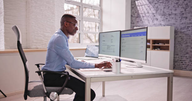 istock Young Businessman Looking At Invoice While Doing Online Banking 1474486843