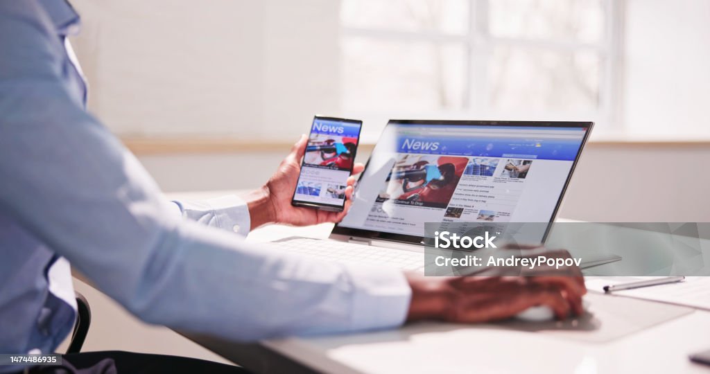 Watching News On Screen. Reading Newspaper Website Watching News On Screen. Reading Newspaper Website On Laptop Newspaper Stock Photo