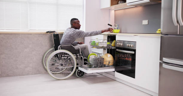 istock Young Man Sitting On Wheelchair Arranging Plates 1474486967